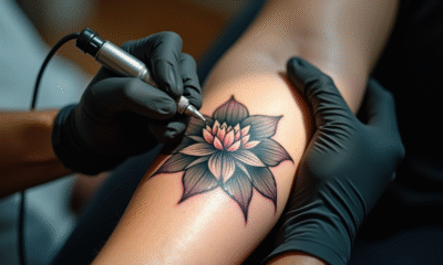 Tatoueur appliquant un tatouage lotus sur le bras en studio lumineux