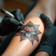 Tatoueur appliquant un tatouage lotus sur le bras en studio lumineux